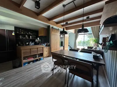 Charming open-layout living and dining area with wooden beams and modern decor.