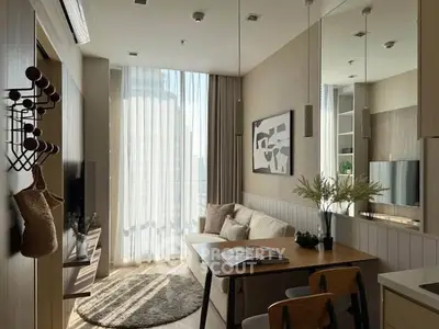 Modern living room with natural light, cozy seating, and stylish decor in a high-rise apartment.