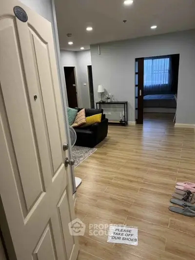Spacious apartment entrance with cozy living area and inviting bedroom view.