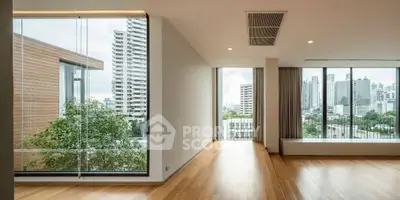 Spacious modern apartment with large windows offering stunning city views and natural light.