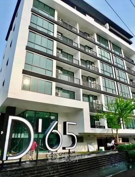 Modern condominium building with sleek design and large windows, showcasing urban living at its finest.