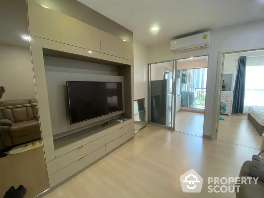 Modern living room with TV unit and balcony access in stylish apartment