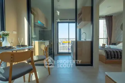 Modern apartment with open kitchen and cozy bedroom, featuring a balcony with city view.