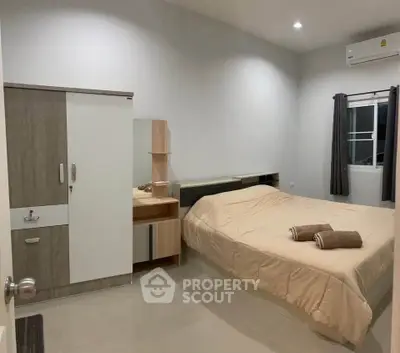 Cozy bedroom with modern furnishings and air conditioning, perfect for relaxation.