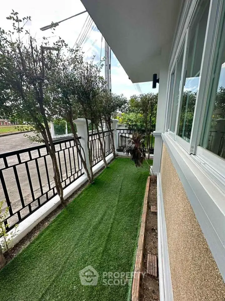 Charming garden view with lush greenery and modern fence, perfect for outdoor relaxation.