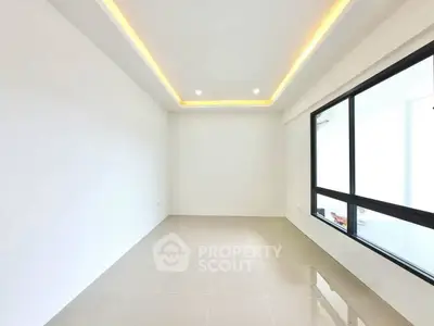 Spacious modern room with large window and elegant ceiling lighting