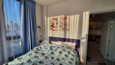 Cozy bedroom with city view, featuring stylish decor and ample natural light.