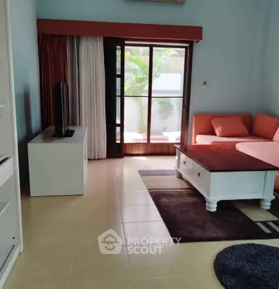 Spacious living room with modern furniture and large window offering natural light.