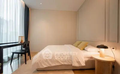 Modern bedroom with cozy bed, stylish decor, and natural light through large window.