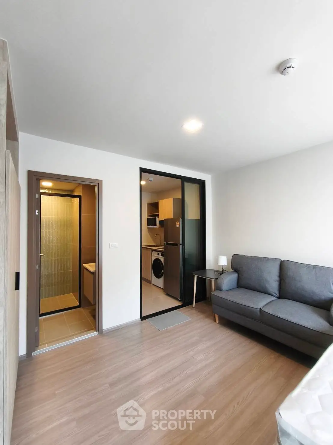 Modern living room with open kitchen and bathroom view