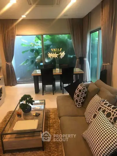 Luxurious living room with elegant decor and large windows overlooking lush greenery.