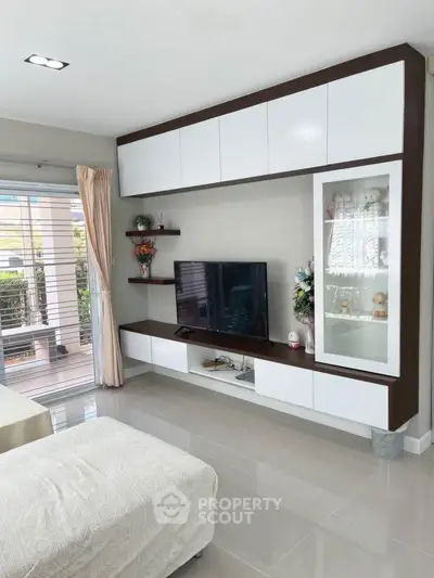 Modern living room with sleek built-in cabinets and large window for natural light.