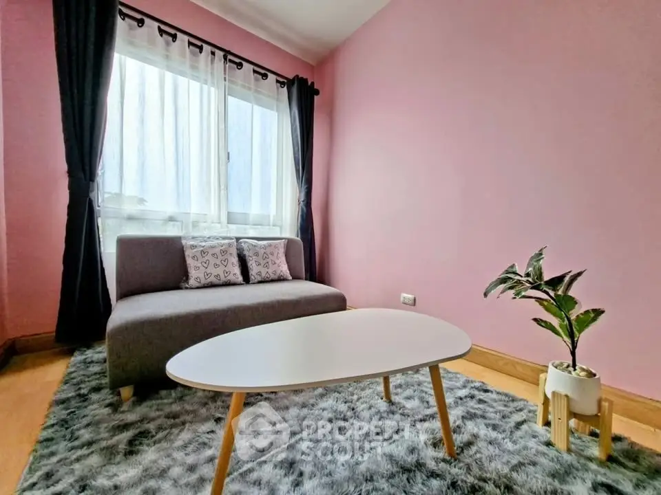 Cozy living room with pink walls, modern sofa, and stylish coffee table.