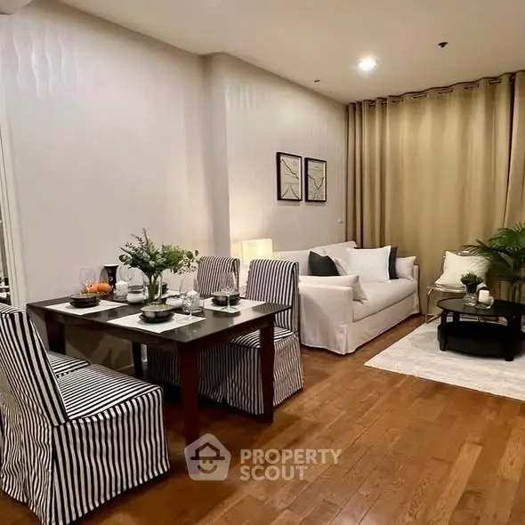 Chic modern living room with dining area, featuring elegant decor and cozy ambiance.