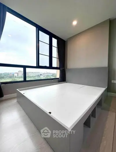 Modern bedroom with large windows and built-in storage bed, offering a bright and spacious atmosphere.