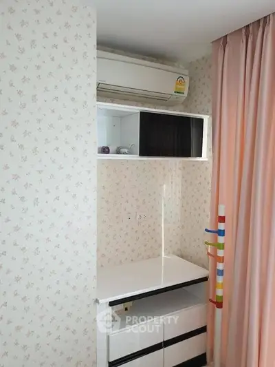 Charming bedroom corner with air conditioning and floral wallpaper, perfect for cozy living.
