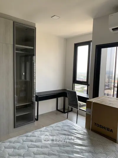 Modern bedroom with large windows and a study desk overlooking city view