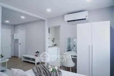 Modern studio apartment with sleek design and air conditioning, featuring a cozy living area and compact kitchen.