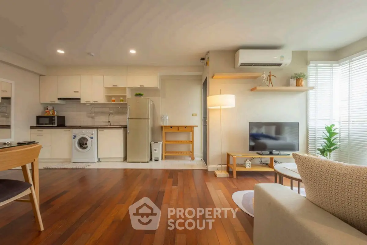 Spacious open-plan living room with modern kitchen and hardwood floors