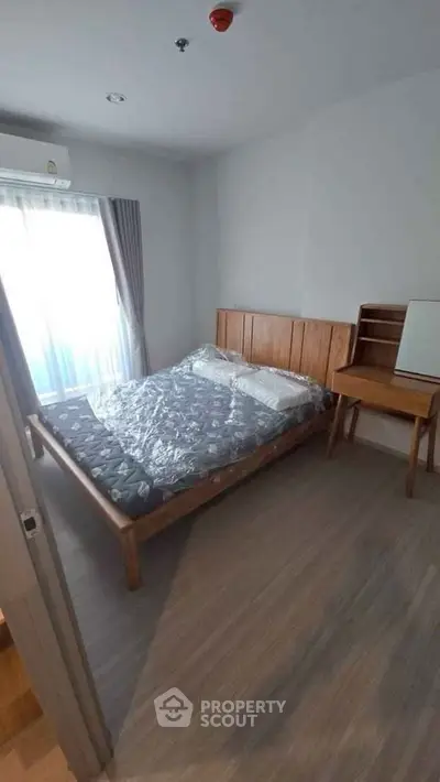 Cozy bedroom with wooden furniture and natural light from large window