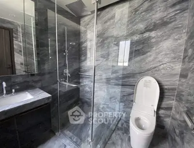 Luxurious marble bathroom with glass shower and modern fixtures