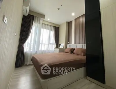 Modern bedroom with stylish decor and large windows for natural light.