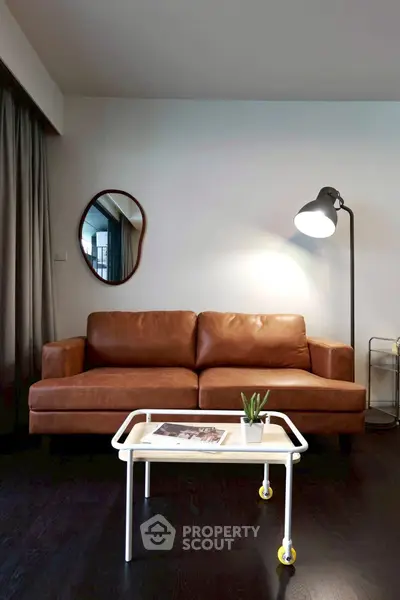 Stylish living room with leather sofa, modern lamp, and chic decor
