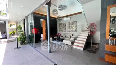 Modern living room with stylish decor and open layout, featuring a cozy sofa and elegant staircase.
