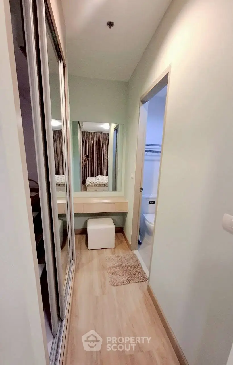 Cozy hallway with vanity leading to a modern bathroom in a stylish apartment.