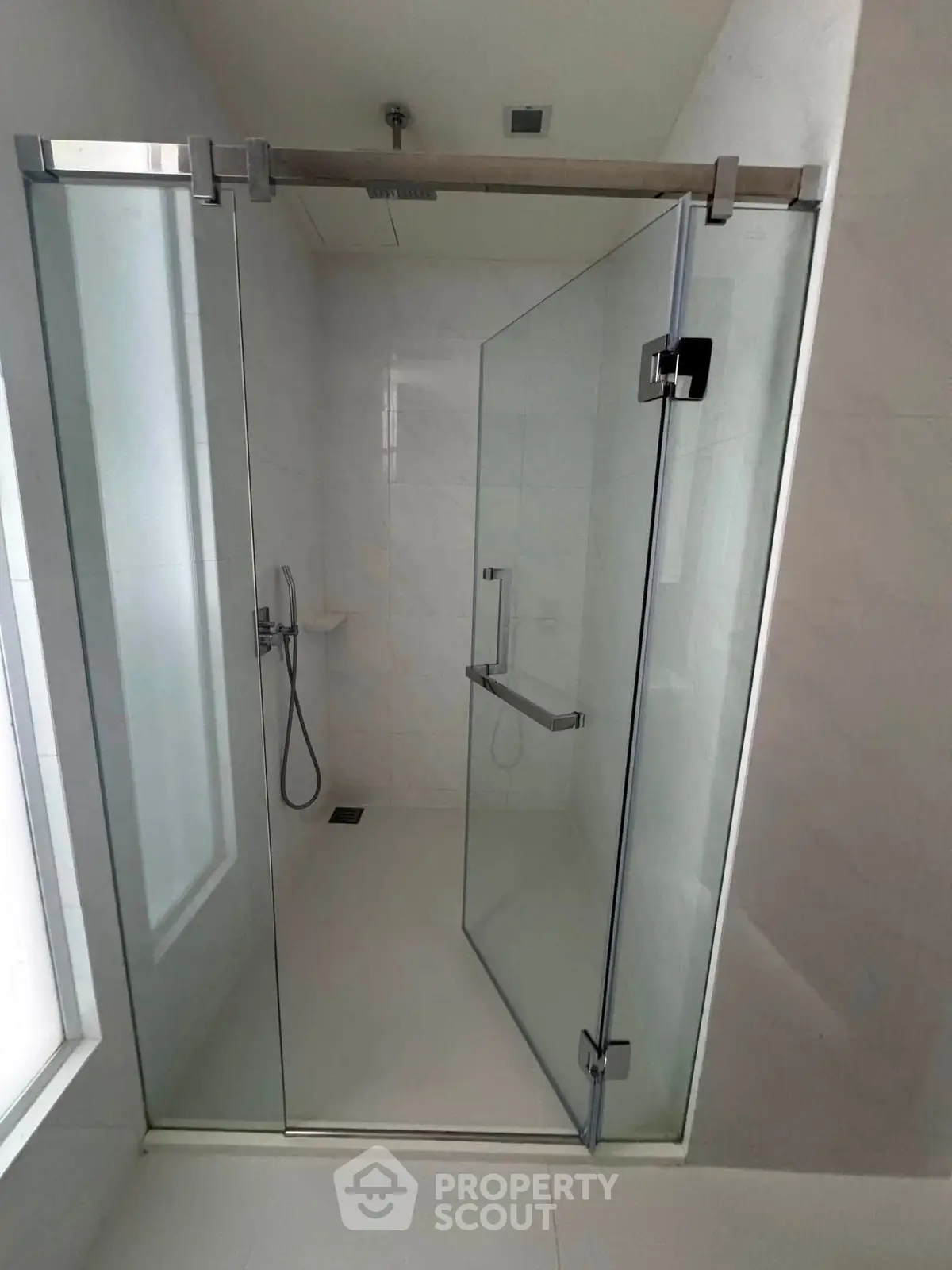 Modern bathroom with sleek glass shower enclosure and minimalist design.