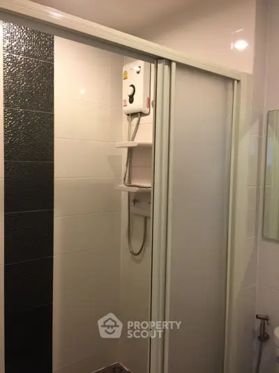 Modern bathroom with sleek shower enclosure and stylish black tile accent wall.