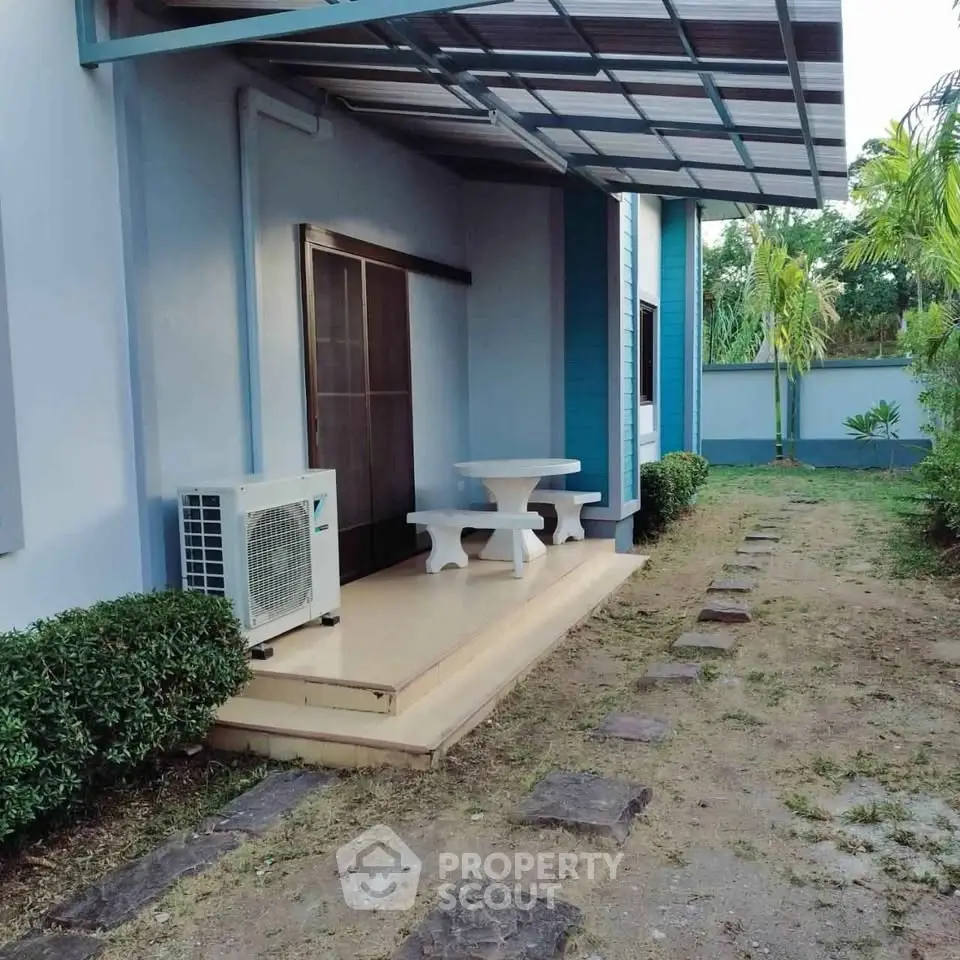 Charming outdoor patio with seating area and lush garden view, perfect for relaxation and entertaining.