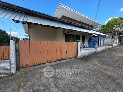 Charming single-story home with modern roof design and wooden fence in a serene neighborhood.