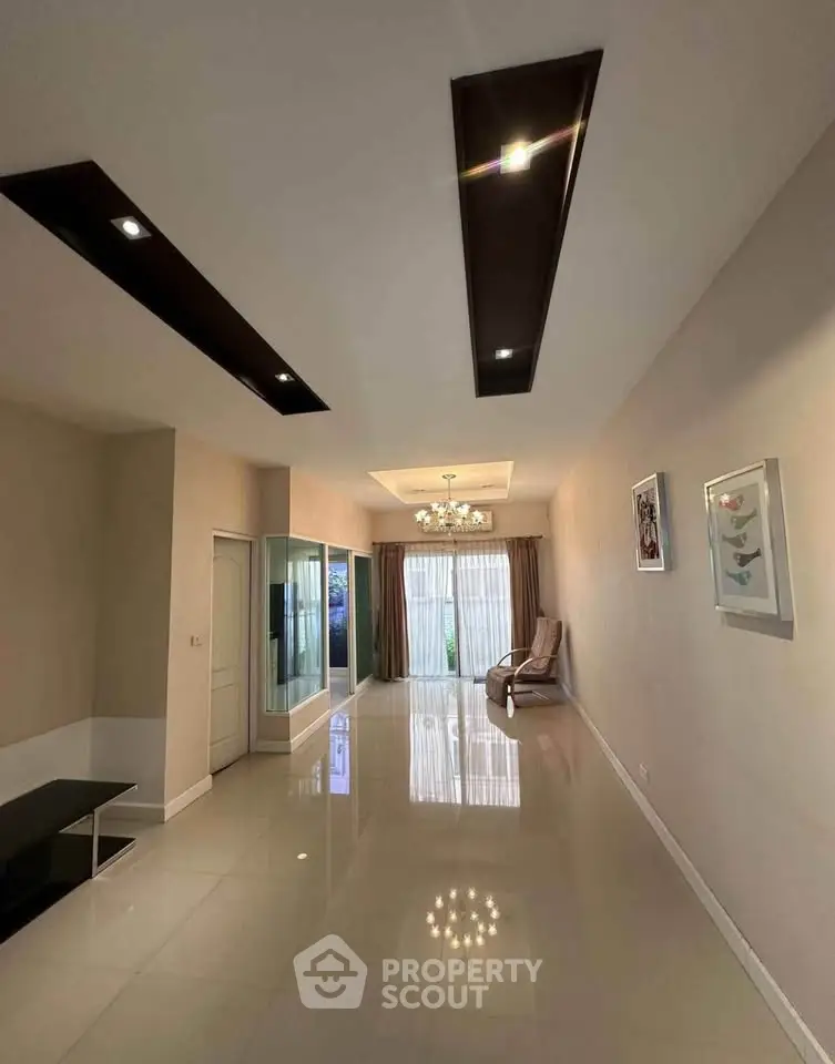 Spacious modern living room with elegant lighting and large windows for natural light.