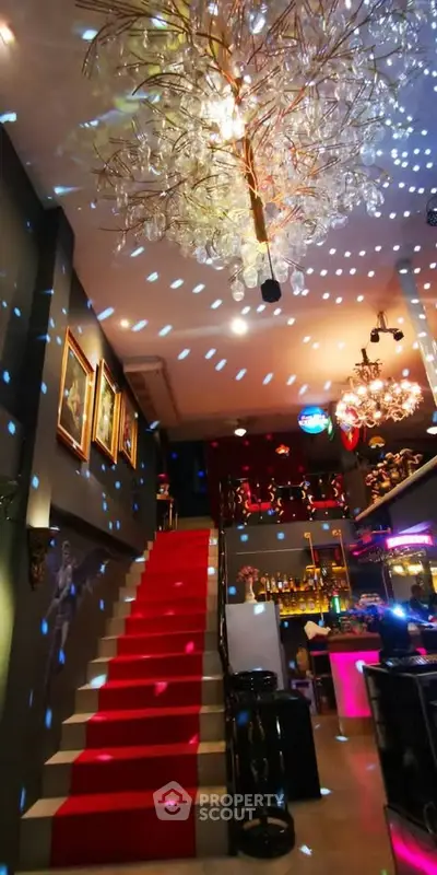 Luxurious interior with grand staircase and dazzling chandelier lighting