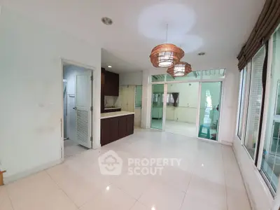 Spacious open-plan living area with modern kitchen and stylish lighting fixtures.