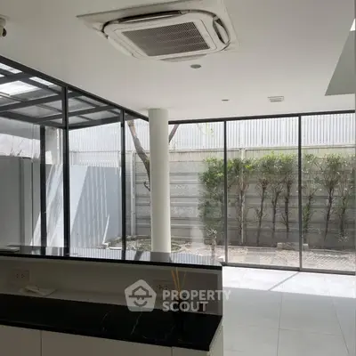 Modern interior with large windows and sleek design, featuring a spacious open layout and abundant natural light.