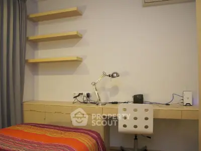 Modern study room with desk, chair, and shelves in cozy apartment