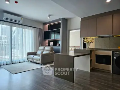 Modern open-layout living room with sleek kitchen and natural light