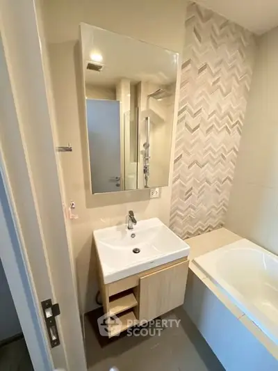 Modern bathroom with stylish vanity and bathtub in contemporary home.