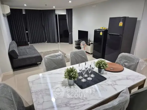 Modern living room with dining area and sleek furniture in a stylish apartment.