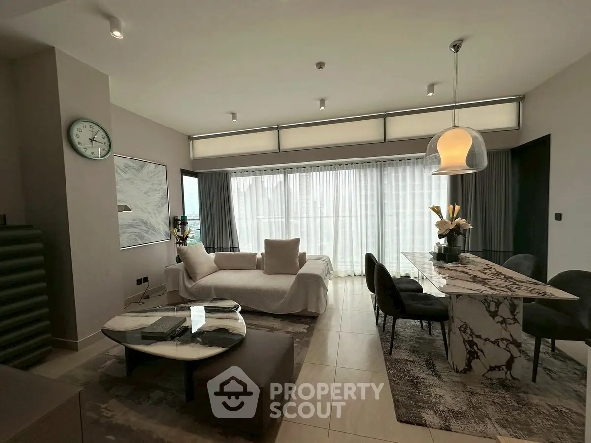Luxurious modern living room with elegant marble dining table and plush seating.