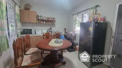 Cozy kitchen space with traditional wooden dining set and ample storage, complemented by modern appliances and natural light.