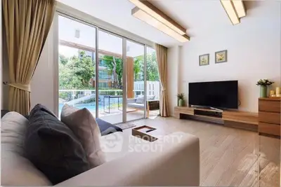 Spacious living room with modern decor and large windows overlooking a lush garden view.