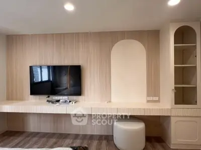 Modern living room with wall-mounted TV and stylish shelving