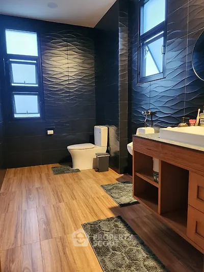 Luxurious modern bathroom with textured walls and wooden flooring