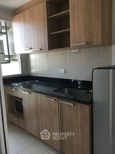 Modern kitchen with wooden cabinets and sleek black countertop