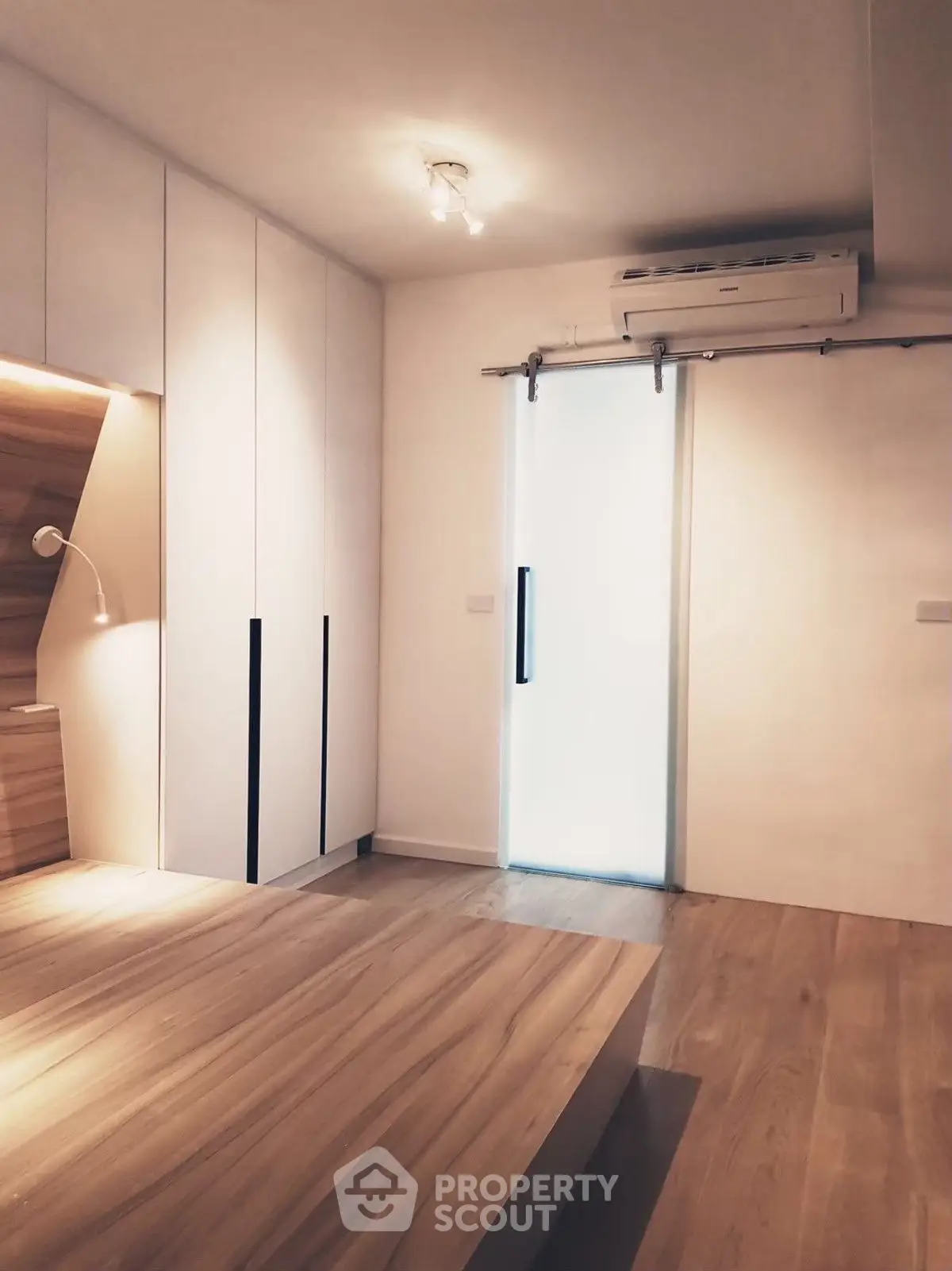 Modern minimalist bedroom with wooden flooring and sliding door