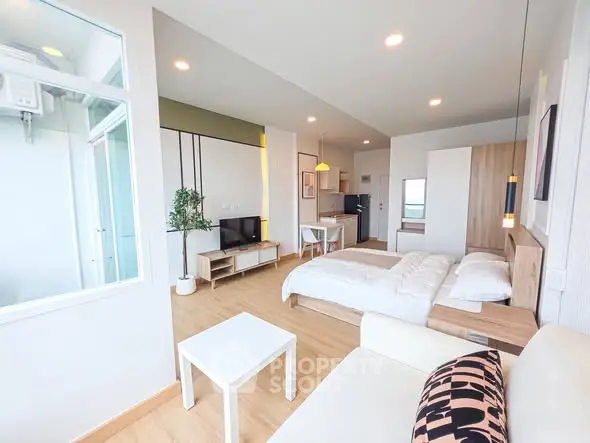 Modern studio apartment with open layout, featuring cozy living area and stylish kitchen.