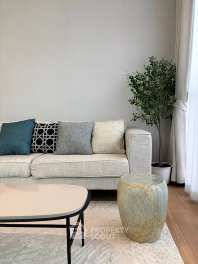 Modern living room with stylish sofa, decorative pillows, and elegant indoor plant.